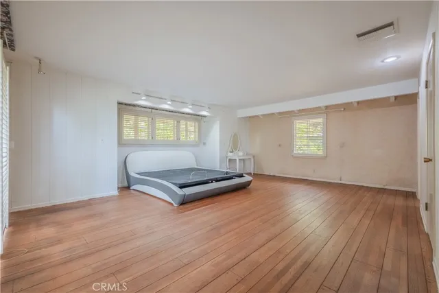 an empty room with windows and wooden floor