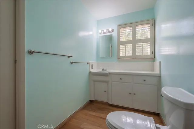 a bathroom with a granite countertop toilet sink and mirror