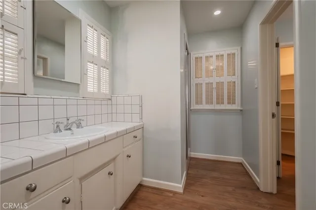 a bathroom with a granite countertop sink and a window