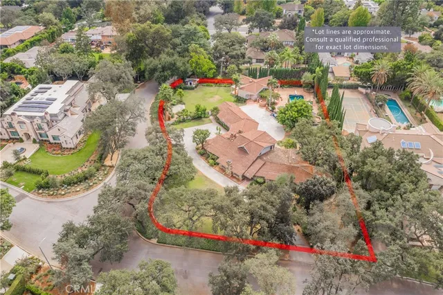 an aerial view of a house with a yard and large trees