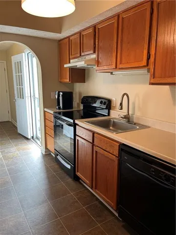 a kitchen with a sink a refrigerator and cabinets