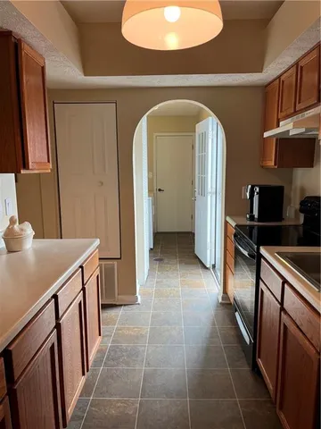 a kitchen with stainless steel appliances granite countertop a sink a refrigerator and cabinets