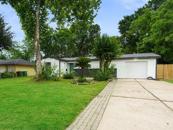 a front view of a house with a yard and trees