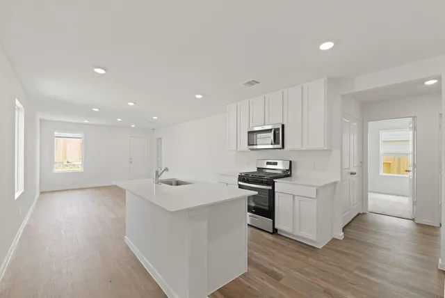 a kitchen with stainless steel appliances granite countertop a sink and cabinets