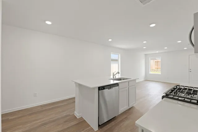 a kitchen with granite countertop a sink and a stove top oven