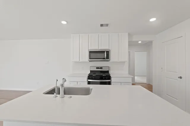 a kitchen with a sink a stove and microwave