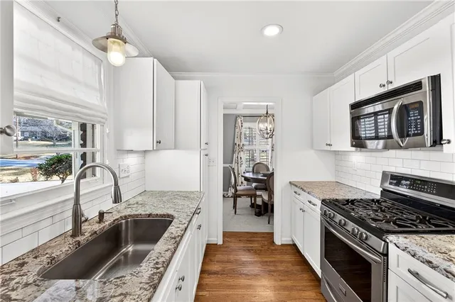 a kitchen with a stove a sink and a microwave