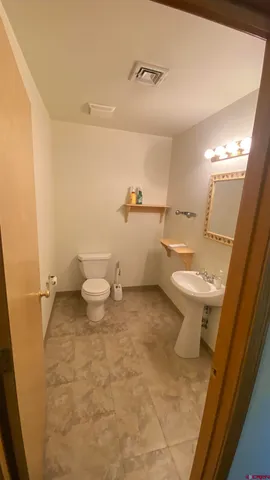 a bathroom with a granite countertop toilet and a sink