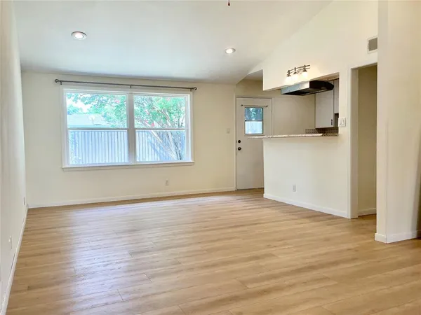 an empty room with wooden floor and a window