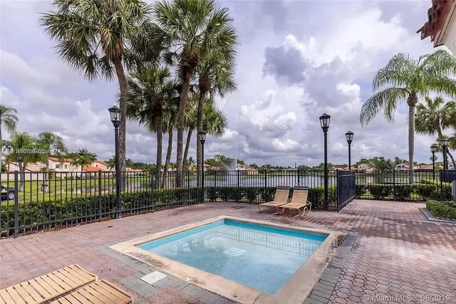 a swimming pool with outdoor seating and a garden