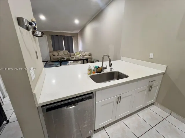 a kitchen with a sink a refrigerator and cabinets