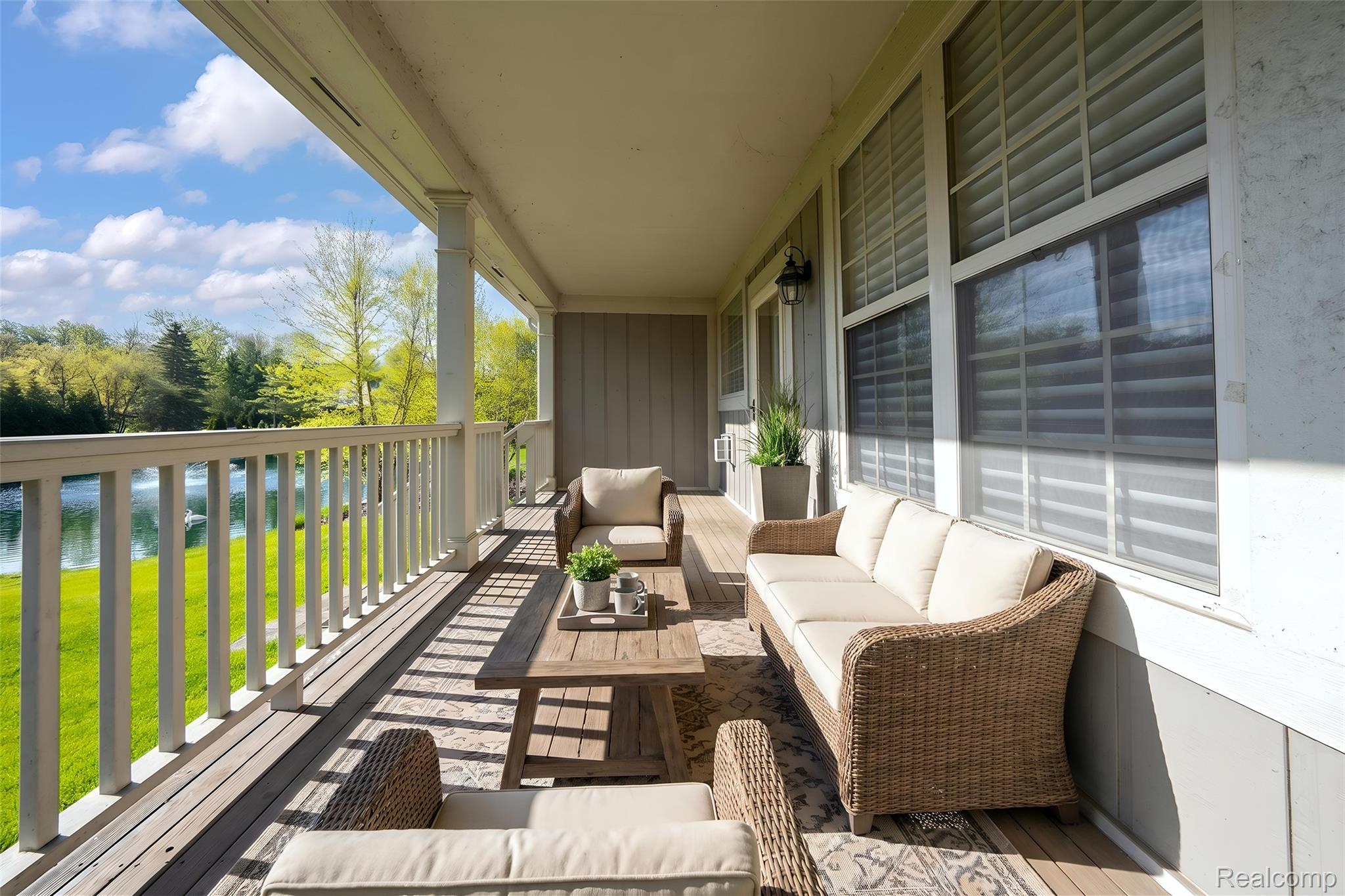3805 Windingbrook Circle, Unit 22 Rochester, MI 48309 - Photo 54 of 63 Expansive covered porch featuring a painted wood railing, wood flooring, and a serene water backdrop