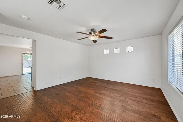 an empty room with fan and windows