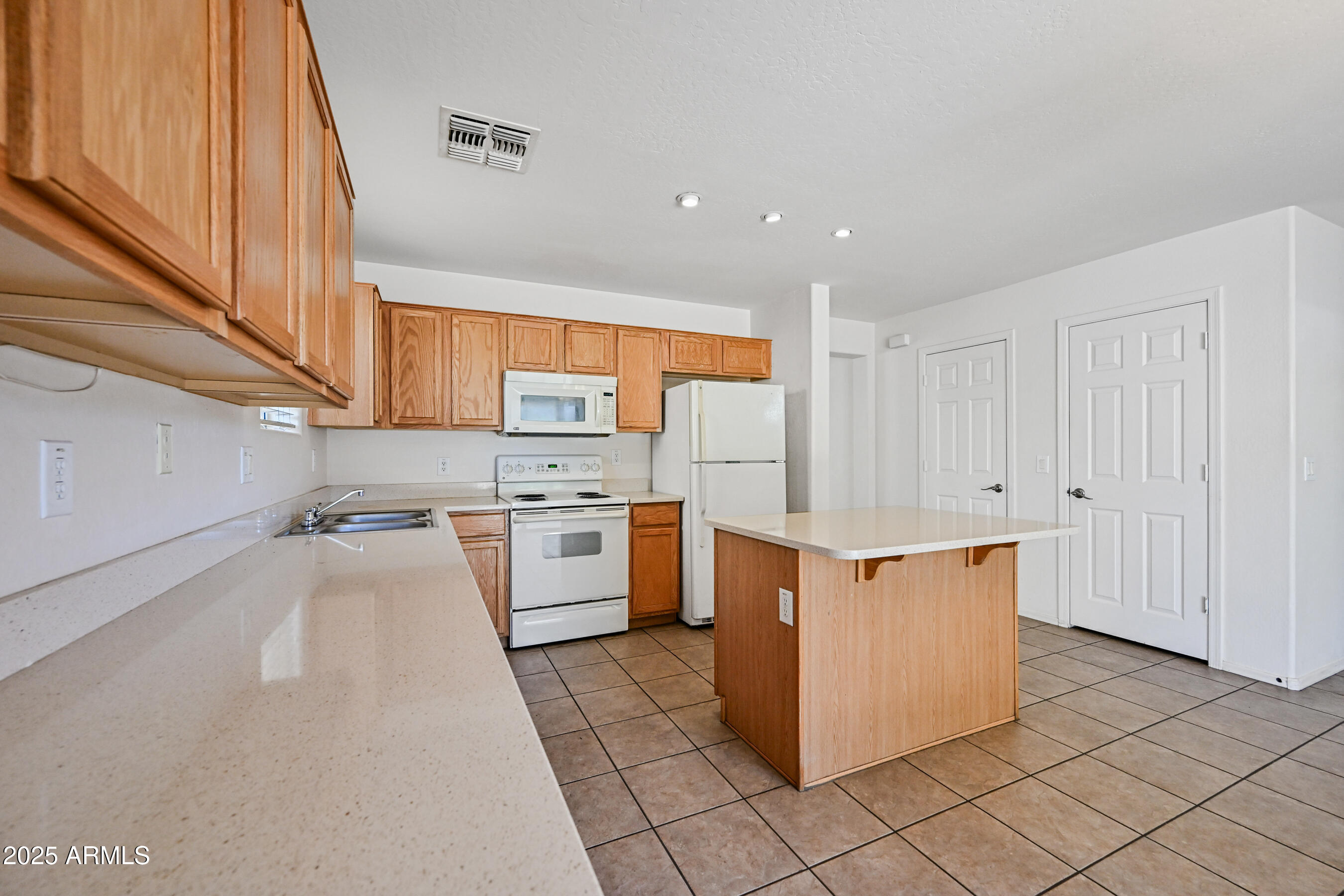 3726 West Pollack Street Phoenix, AZ 85041 - Photo 9 of 27 a kitchen with stainless steel appliances a stove a refrigerator a sink and white cabinets