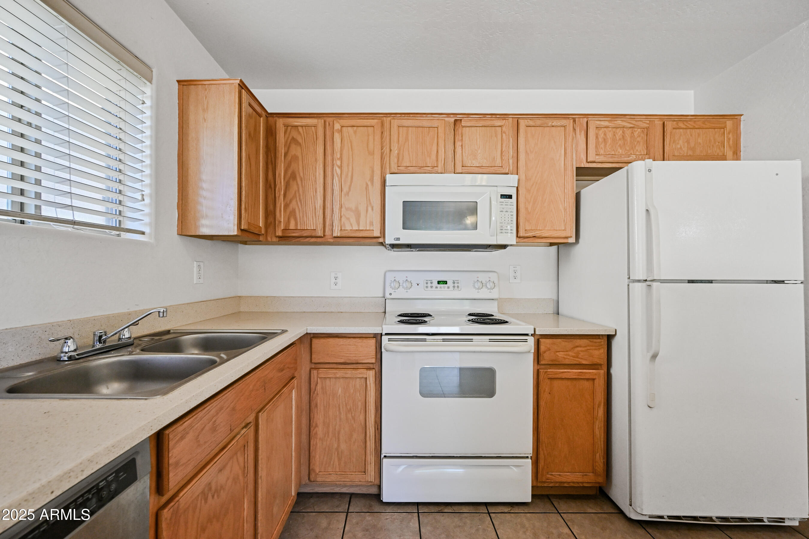 3726 West Pollack Street Phoenix, AZ 85041 - Photo 10 of 27 a kitchen with a sink a stove a refrigerator and cabinets