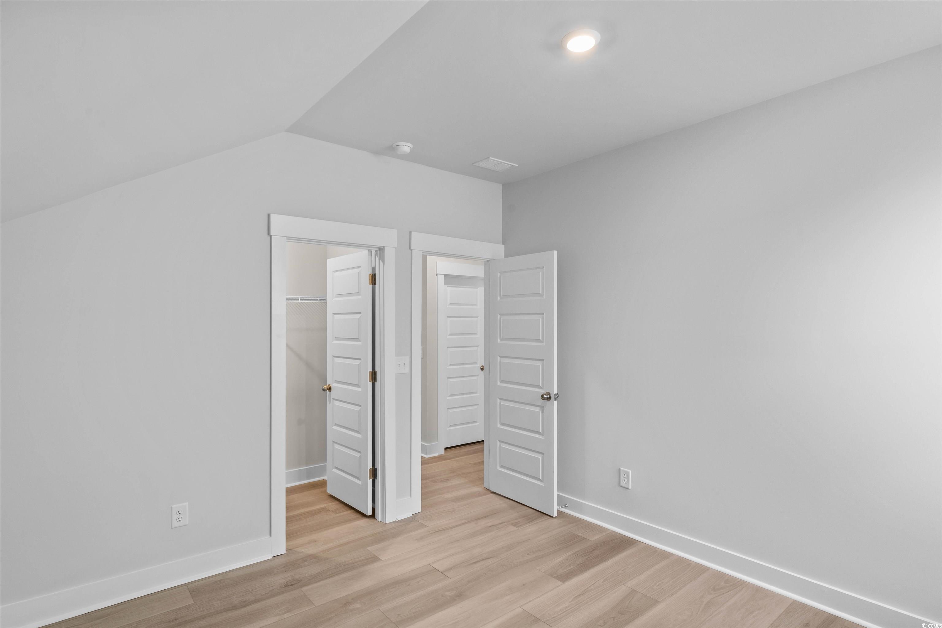 205 Atlantic Breeze Street Myrtle Beach, SC 29572 - Photo 10 of 28 Unfurnished bedroom featuring a spacious closet, light wood-type flooring, and lofted ceiling