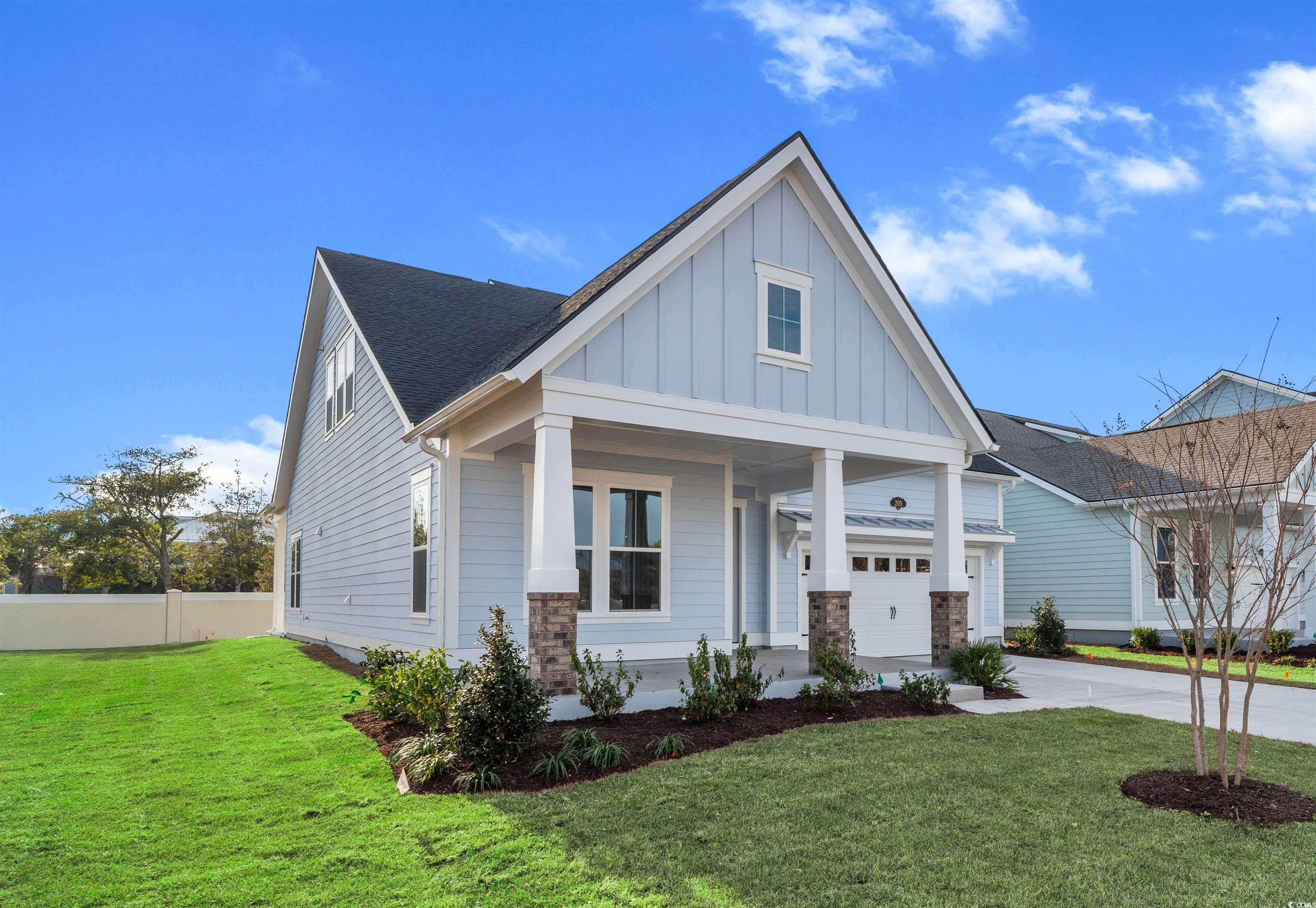 205 Atlantic Breeze Street Myrtle Beach, SC 29572 - Photo 4 of 28 View of front facade with board and batten siding, a porch, a garage, driveway, and roof with shingles