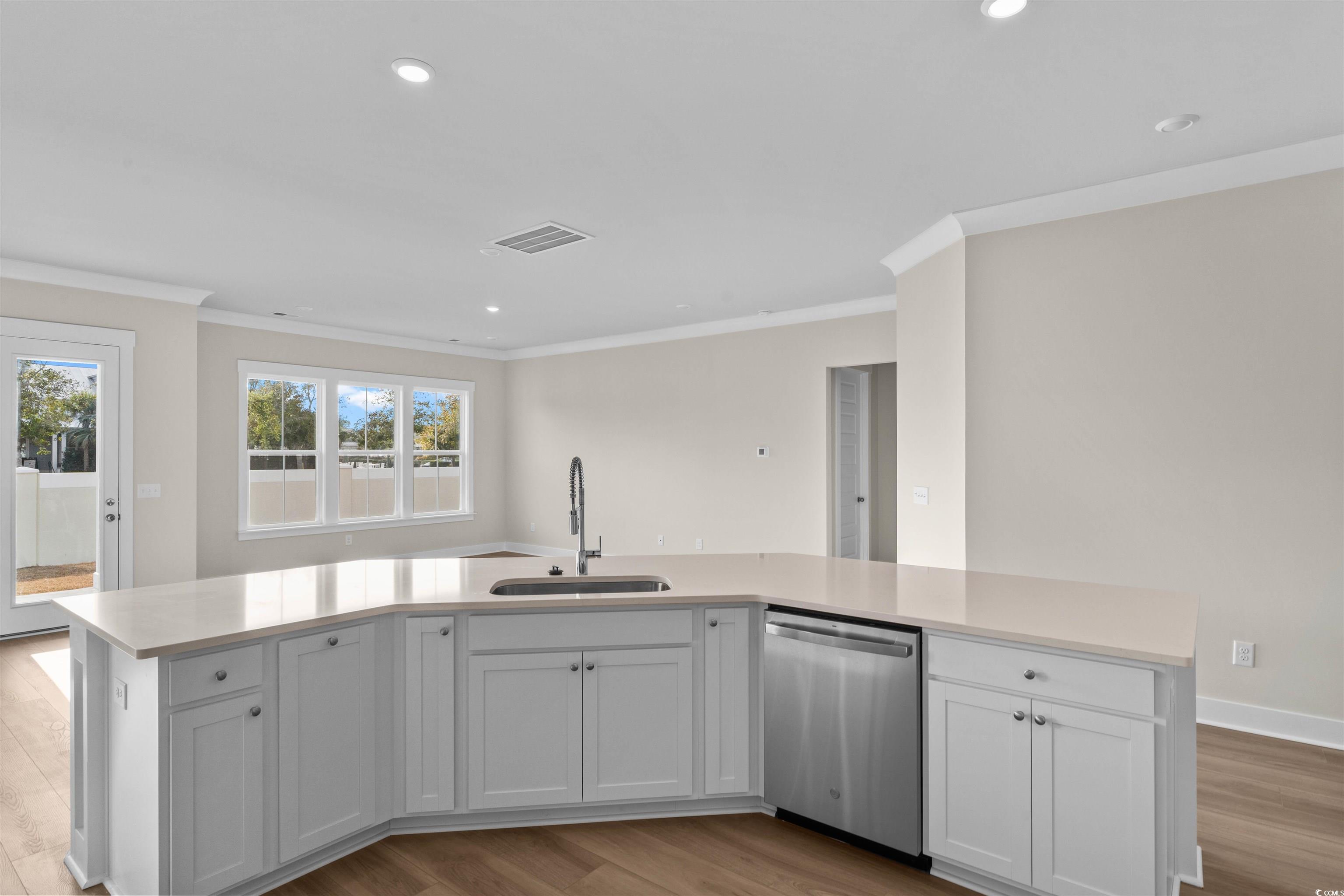 205 Atlantic Breeze Street Myrtle Beach, SC 29572 - Photo 6 of 28 Kitchen featuring white cabinets, a large island, stainless steel dishwasher, light wood-style floors, and recessed lighting