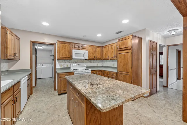 a kitchen with stainless steel appliances granite countertop a sink and a refrigerator