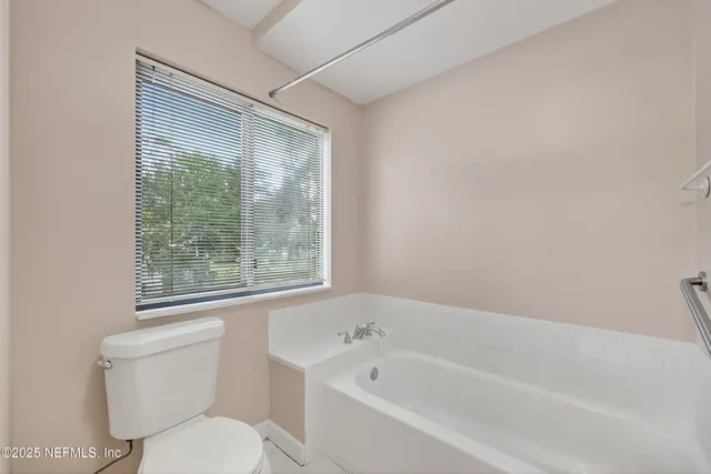a white toilet sitting next to a bath tub