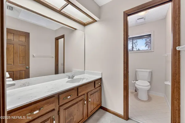 a bathroom with a granite countertop sink mirror and toilet