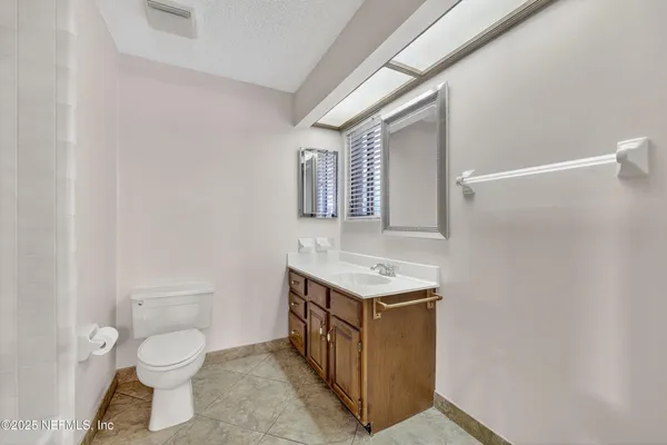 a bathroom with a toilet a sink and mirror