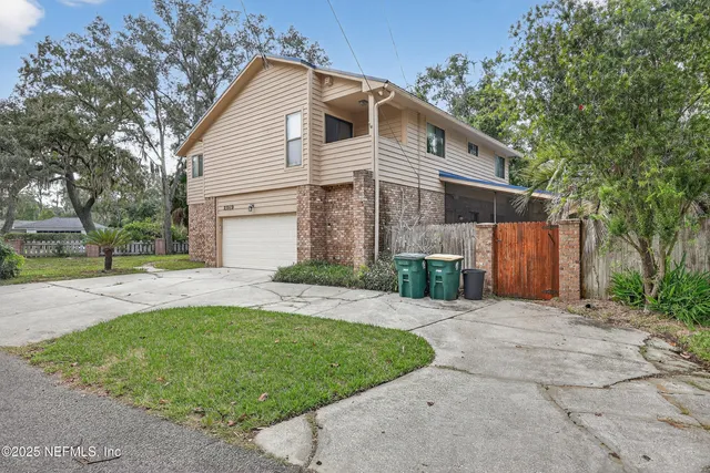 a front view of a house with a yard and potted plants