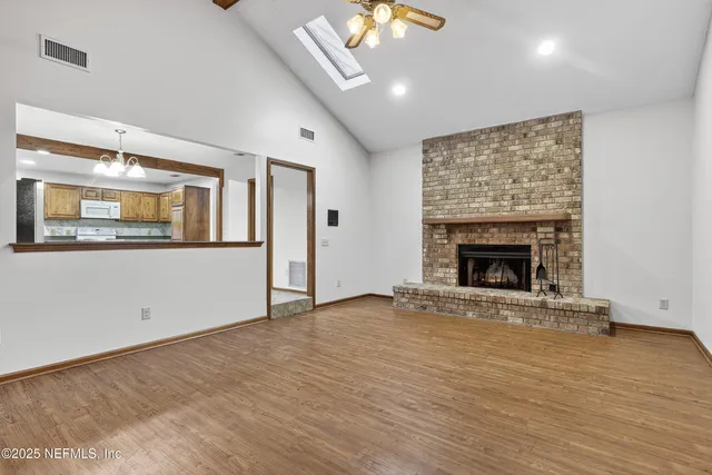 an empty room with wooden floor and fireplace