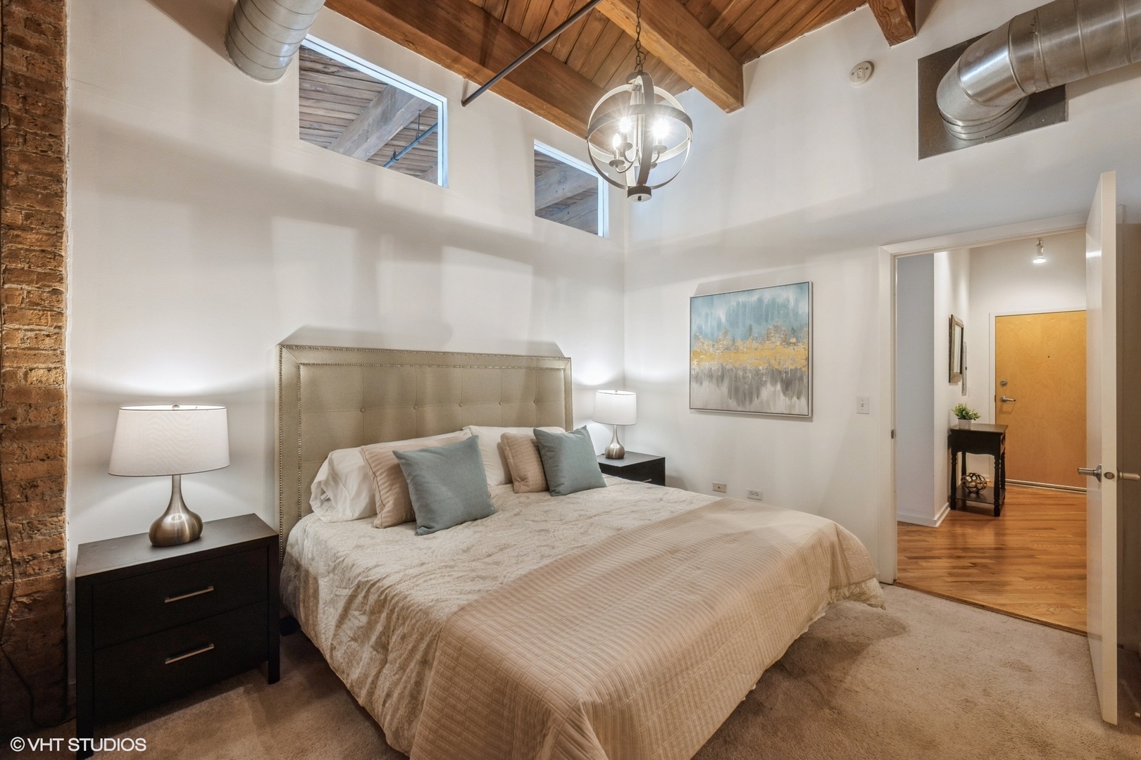 1040 West Adams Street, Unit 442 Chicago, IL 60607 - Photo 13 of 23 a bedroom with a bed and a chandelier