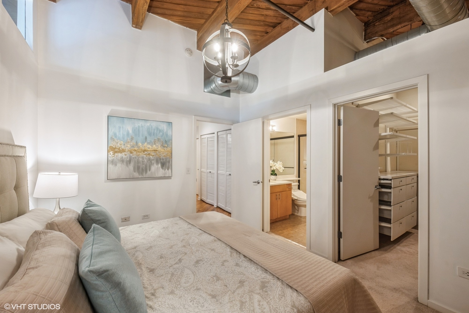 1040 West Adams Street, Unit 442 Chicago, IL 60607 - Photo 14 of 23 a bedroom with a bed and a chandelier
