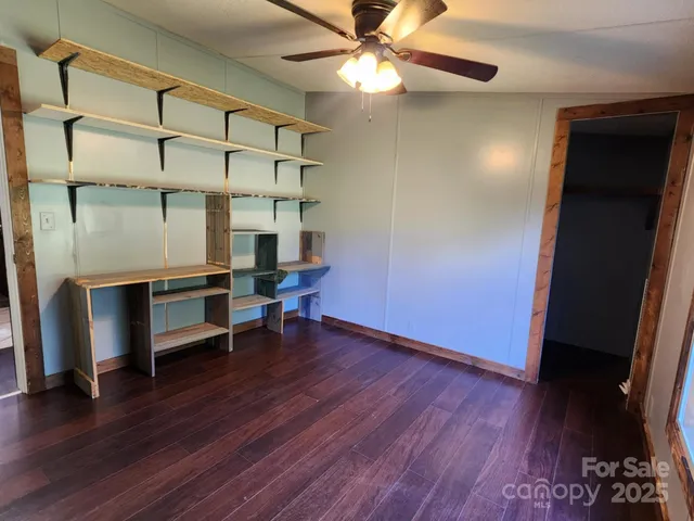 a view of a livingroom with furniture a ceiling fan and wooden floor