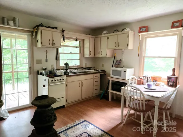 a kitchen with a stove a table and chairs in it