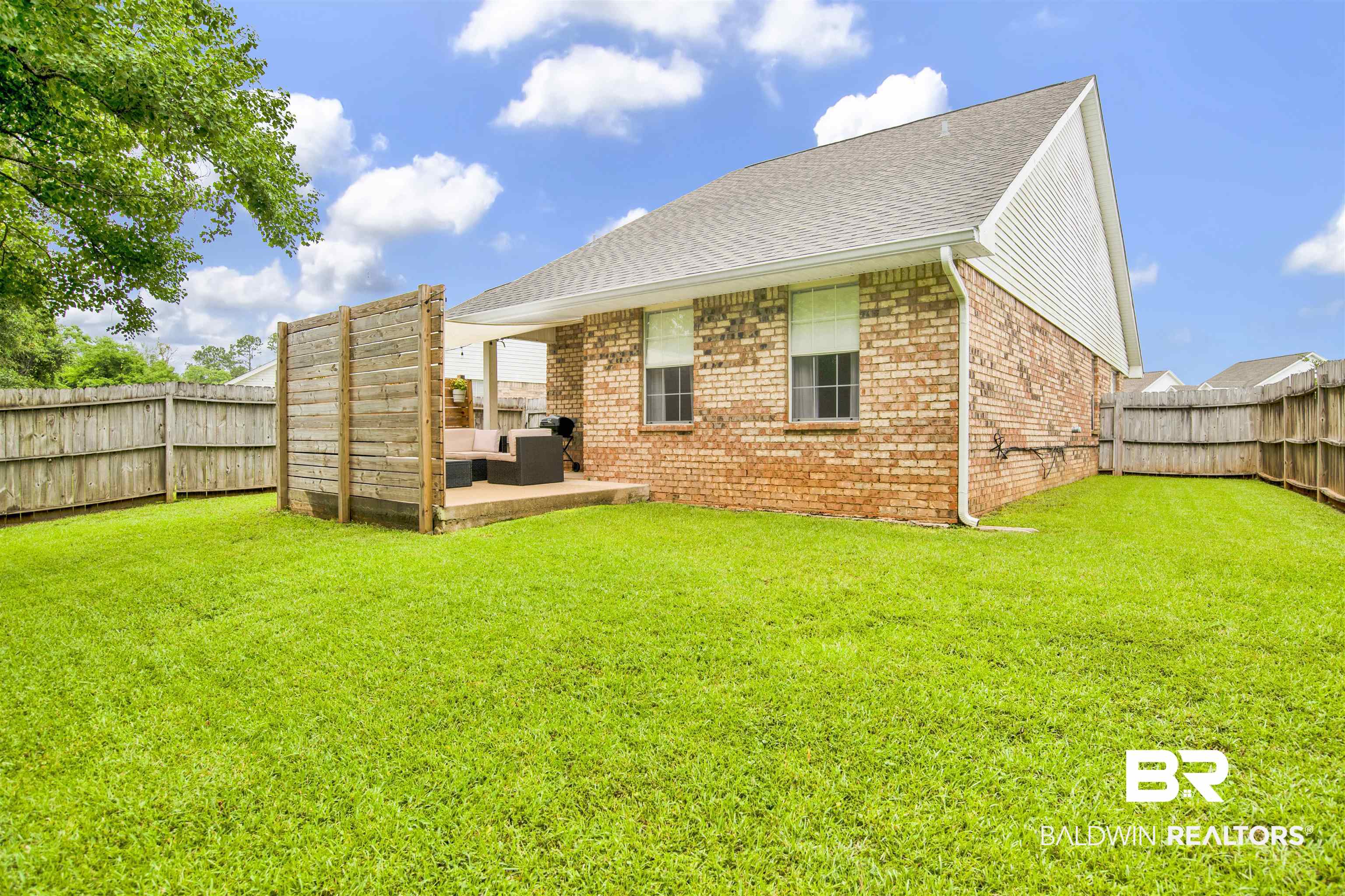 4012 Kendallbrook Loop Foley, AL 36535 - Photo 27 of 31 Back of house with outdoor lounge area, brick siding, a fenced backyard, a patio, and roof with shingles