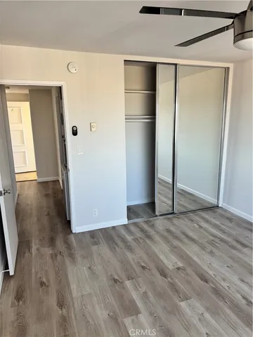 a view of empty room with wooden floor and window