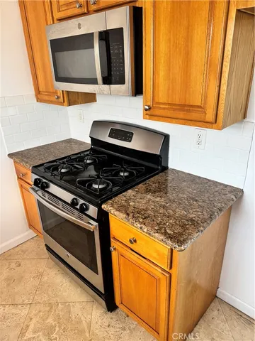 a kitchen with stainless steel appliances granite countertop a stove and a microwave