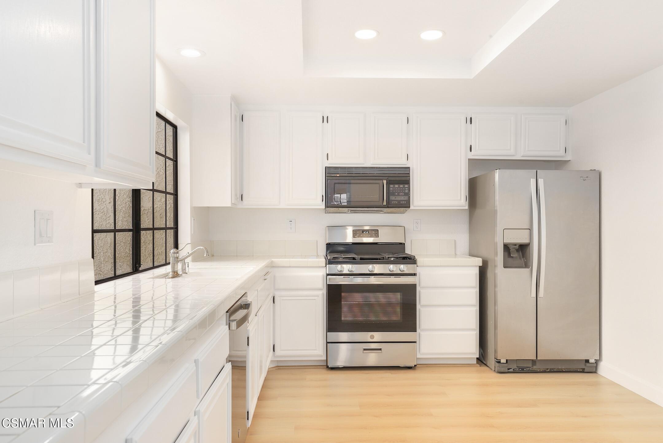 765 Congressional Road Simi Valley, CA 93065 - Photo 16 of 35 a kitchen with stainless steel appliances a stove a refrigerator a sink and white cabinets