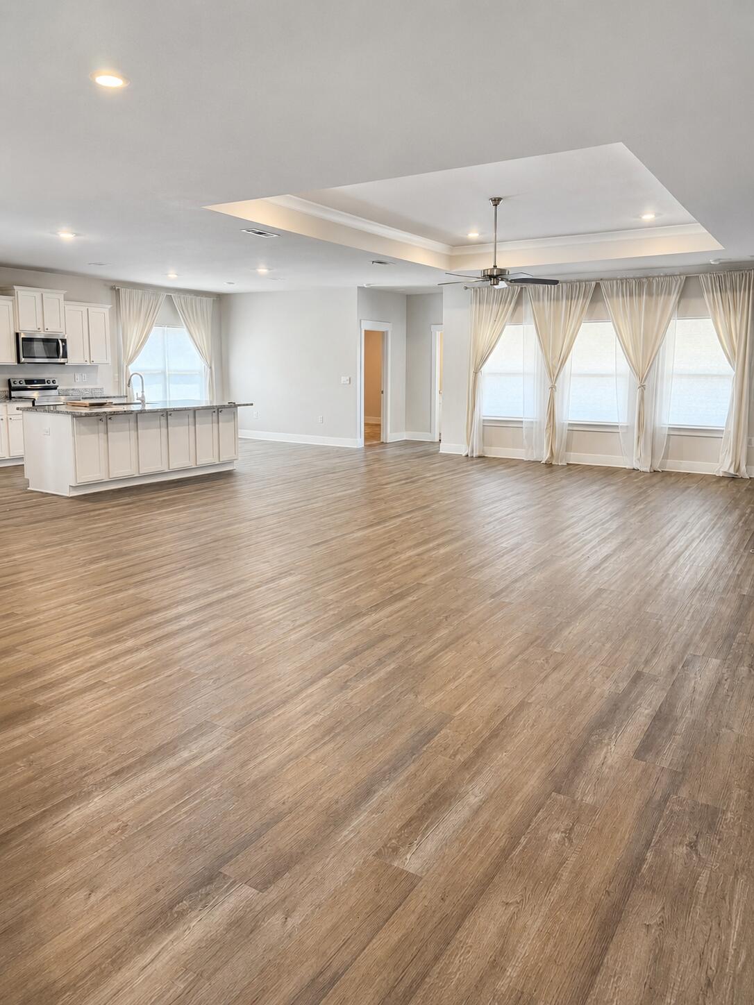 734 Quintana Street Crestview, FL 32539 - Photo 2 of 16 an empty room with wooden floor and windows
