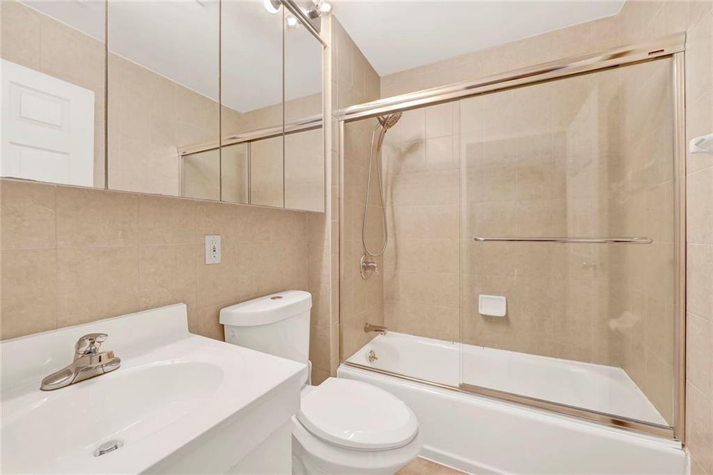 52 92nd Street, Unit 7C Brooklyn, NY 11209 - Photo 20 of 22 a white toilet sitting next to a bathroom sink and vanity