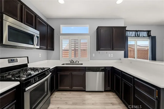 a kitchen with stainless steel appliances kitchen island granite countertop a sink stove and microwave