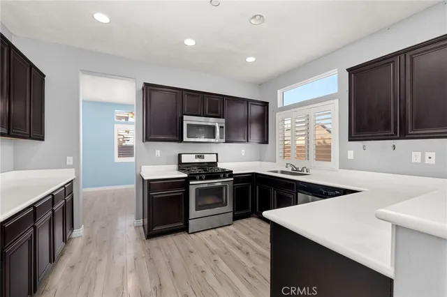 a kitchen with stainless steel appliances kitchen island granite countertop a sink stove and refrigerator