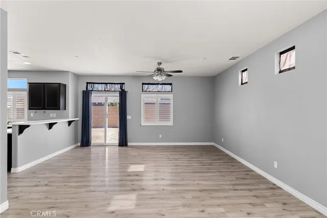 a view of empty room with wooden floor and windows