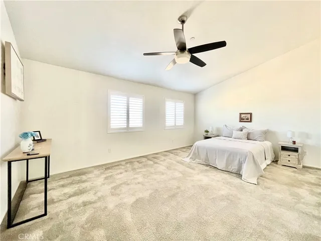a spacious bedroom with a bed and dresser