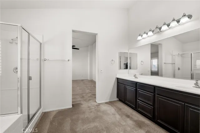 a spacious bathroom with a double vanity sink mirror and shower