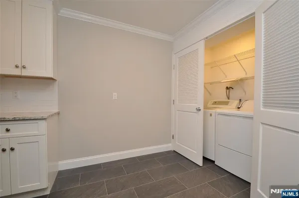 a view of a kitchen with white cabinets and a window