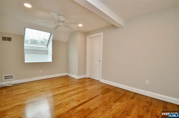 an empty room with a window and wooden floor