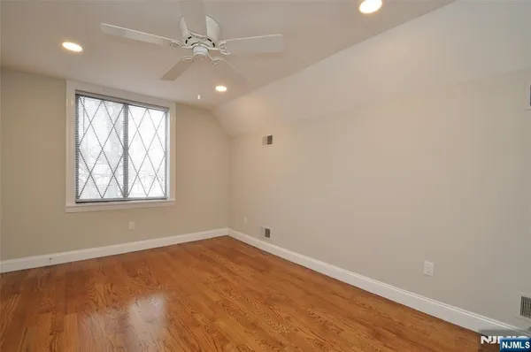 an empty room with a window and ceiling fan