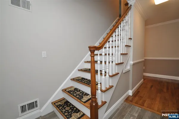 a view of staircase with wooden floor and white walls
