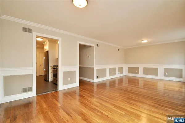 a view of an empty room with wooden floor