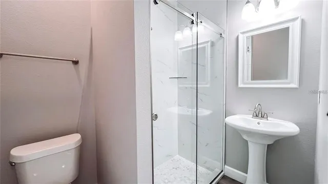 a bathroom with a sink toilet and shower