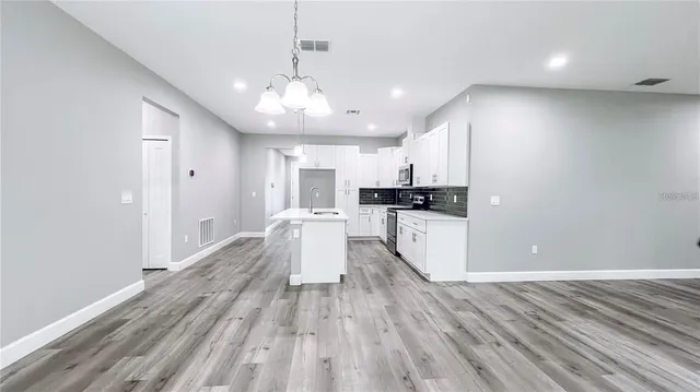 a large kitchen with a lot of counter space and stainless steel appliances